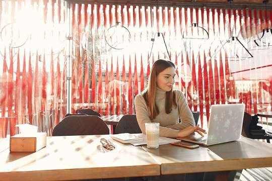 Woman at computer at her cafe doing bookkeeping